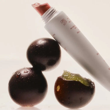 Hydrating lip gloss showcased alongside fresh passion fruit, highlighting the product's natural ingredients and smooth texture